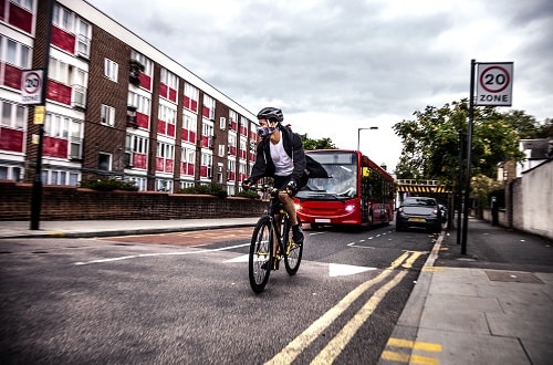 Cyclist Wearing Mask and Bus iStock LeoPatrizi